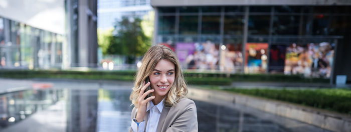 Portrait of young woman standing in city