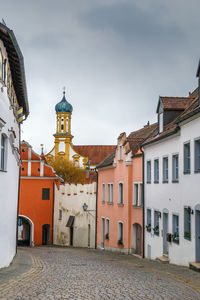 Houses by street in town against sky