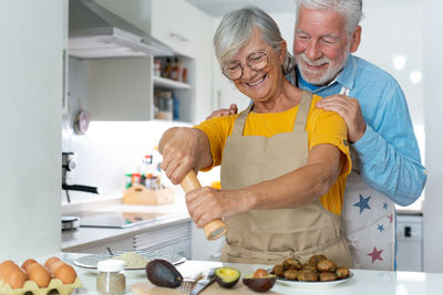 Portrait of smiling senior man holding food at home