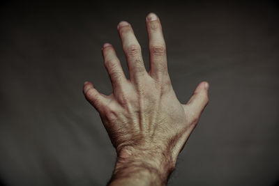 Close-up of human hand against black background