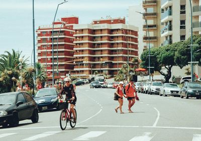 People on street against buildings in city