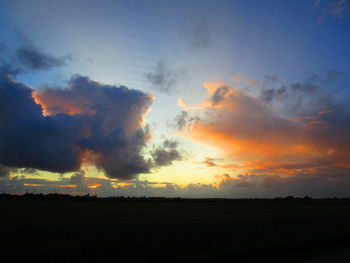 Scenic view of silhouette field against sky during sunset