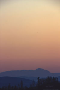 Scenic view of silhouette mountains against clear sky at sunset