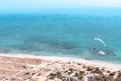 High angle view of person paragliding against sea