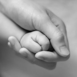 Close-up of woman holding baby hand