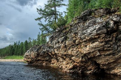 Rock formation on shore against sky