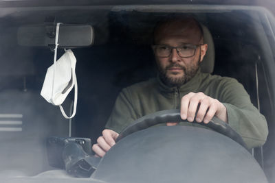 Portrait of man sitting in car