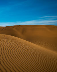 Sand dunes in desert against sky