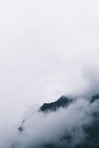 Mountains against cloudy sky during foggy weather