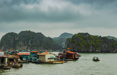 Ha long bay settlement on the water with mountains and clouds in the distance