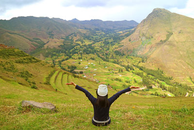 Man with arms outstretched against mountain range