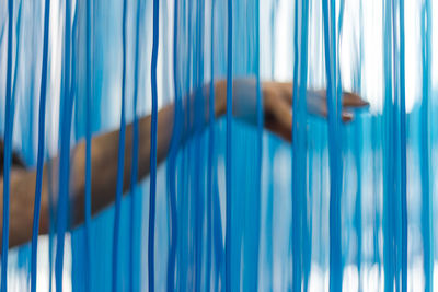 Cropped hand touching blue drapes