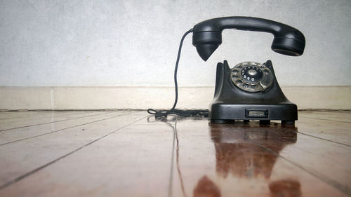 Close-up of telephone booth on table against wall