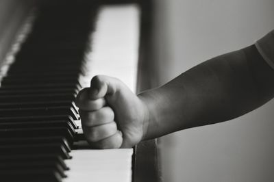 Cropped image of child hand on piano key