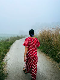 Rear view of woman standing on field