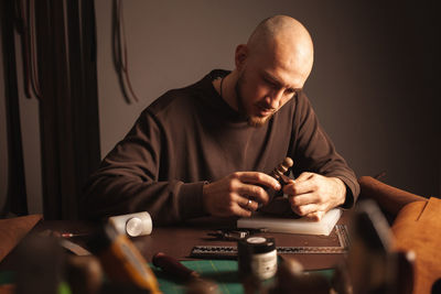 Portrait tanner makes leather wallet, professional craftsman, business. handiwork.