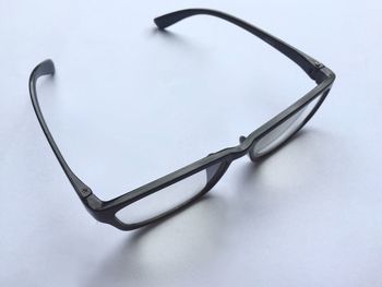 High angle view of eyeglasses on table against white background