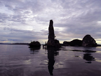 Reflection of rocks in sea against sky