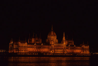 View of historic building by river against sky at night