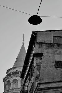 Low angle view of street light by building against sky