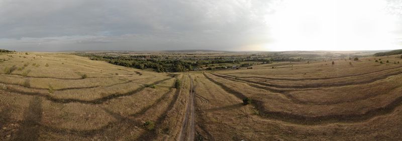 Panoramic view of agricultural field against sky