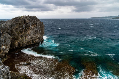 Scenic view of rocks in sea against sky