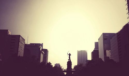 Low angle view of statue in city against clear sky