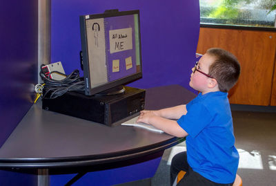A little boy plays at a computer at a learning center