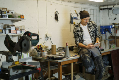 Man using phone in workshop