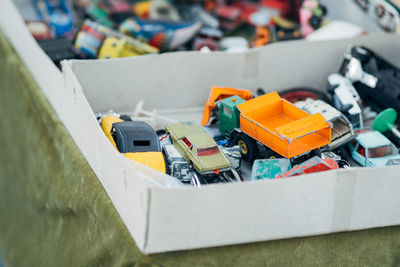 High angle view of weathered toy cars in box