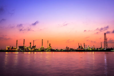 Commercial dock by sea against sky during sunset