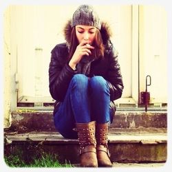 Portrait of young woman sitting on wall