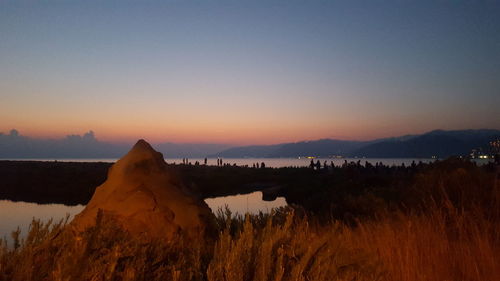 Scenic view of lake against clear sky during sunset