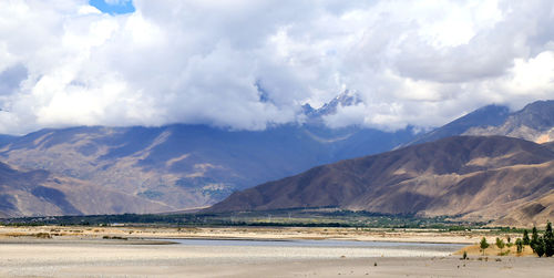 Scenic view of lake by mountains against sky