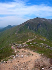 People on mountain road against sky