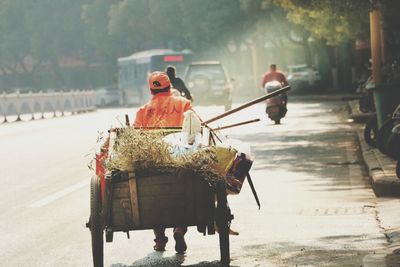 Man driving cart on road in city