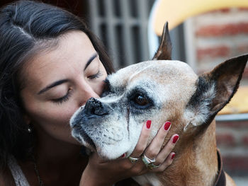 Close-up of young woman kissing dog