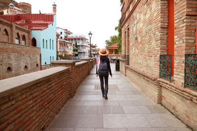 Rear view of woman walking on street in city