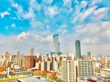 Buildings in city against cloudy sky