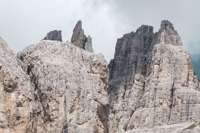 Low angle view of rocky mountains against sky