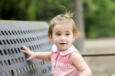 Cute girl looking away by bench