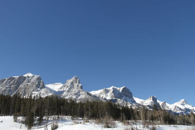 Scenic view of snowcapped mountains against clear blue sky