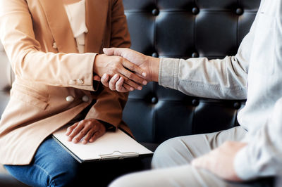 Midsection of couple holding hands