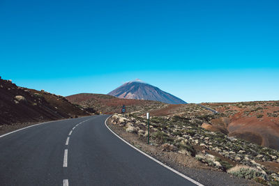 Road by mountains against clear sky