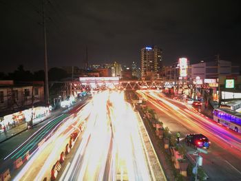 Panoramic view of light trails on road at night