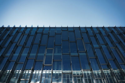 Low angle view of modern building against clear blue sky
