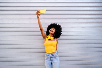 Rear view of woman standing against wall