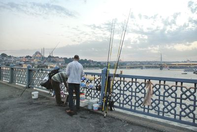 Men standing on bridge over river