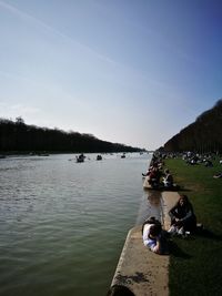 People on lake against sky