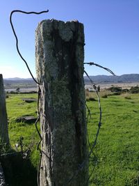 View of wooden post on field against sky